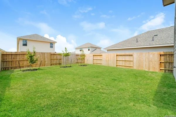 a view of a backyard with wooden fence