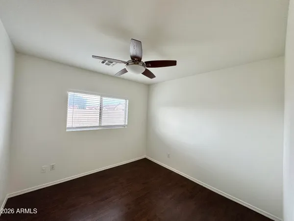 an empty room with a ceiling fan and window