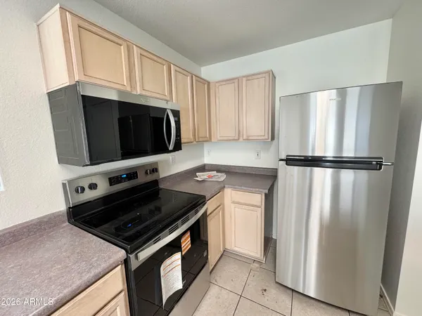 a kitchen with stainless steel appliances granite countertop a refrigerator stove and microwave