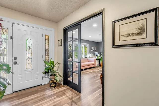 a view of a hallway with wooden floor and furniture