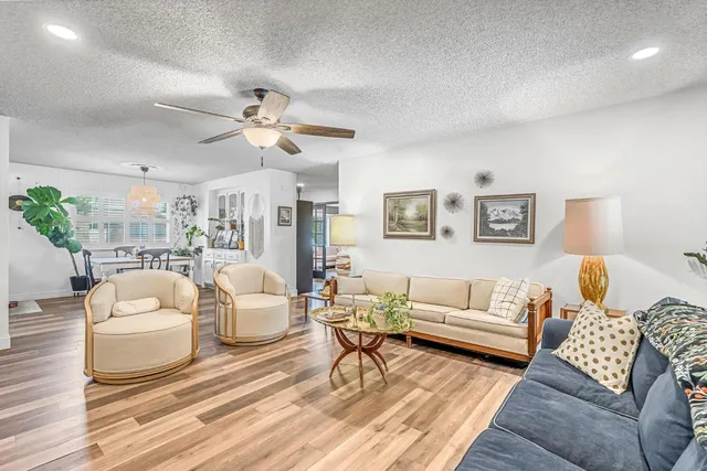 a dining room with furniture a chandelier and wooden floor