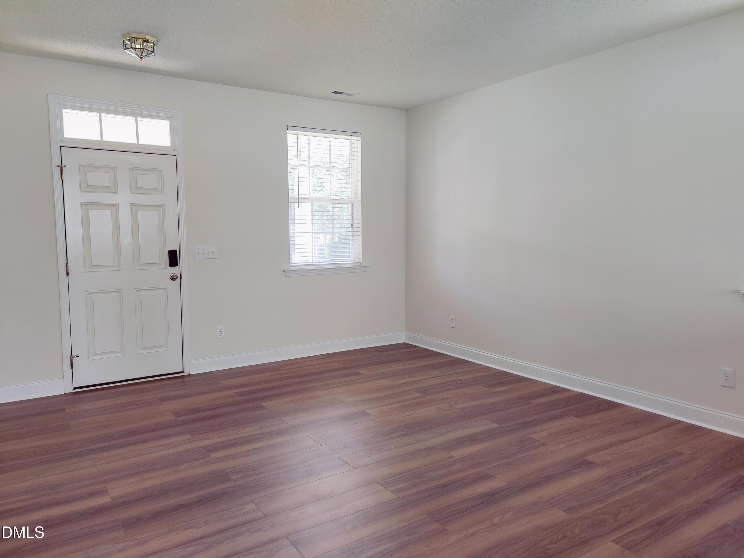 4011 Oatgrass Lane Raleigh, NC 27604 - Photo 4 of 21 an empty room with wooden floor and windows