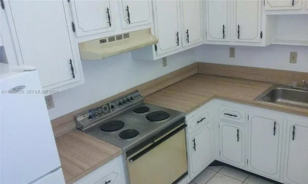 a kitchen with white cabinets and white appliances
