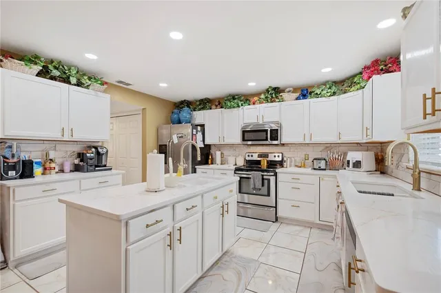 a kitchen with stainless steel appliances granite countertop a sink stove and cabinets