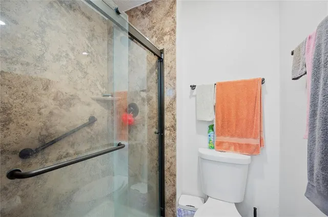 a bed room with a bed a flat screen tv and a book shelf