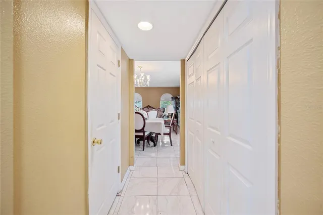 a view of a hallway with a livingroom and a dining room with furniture