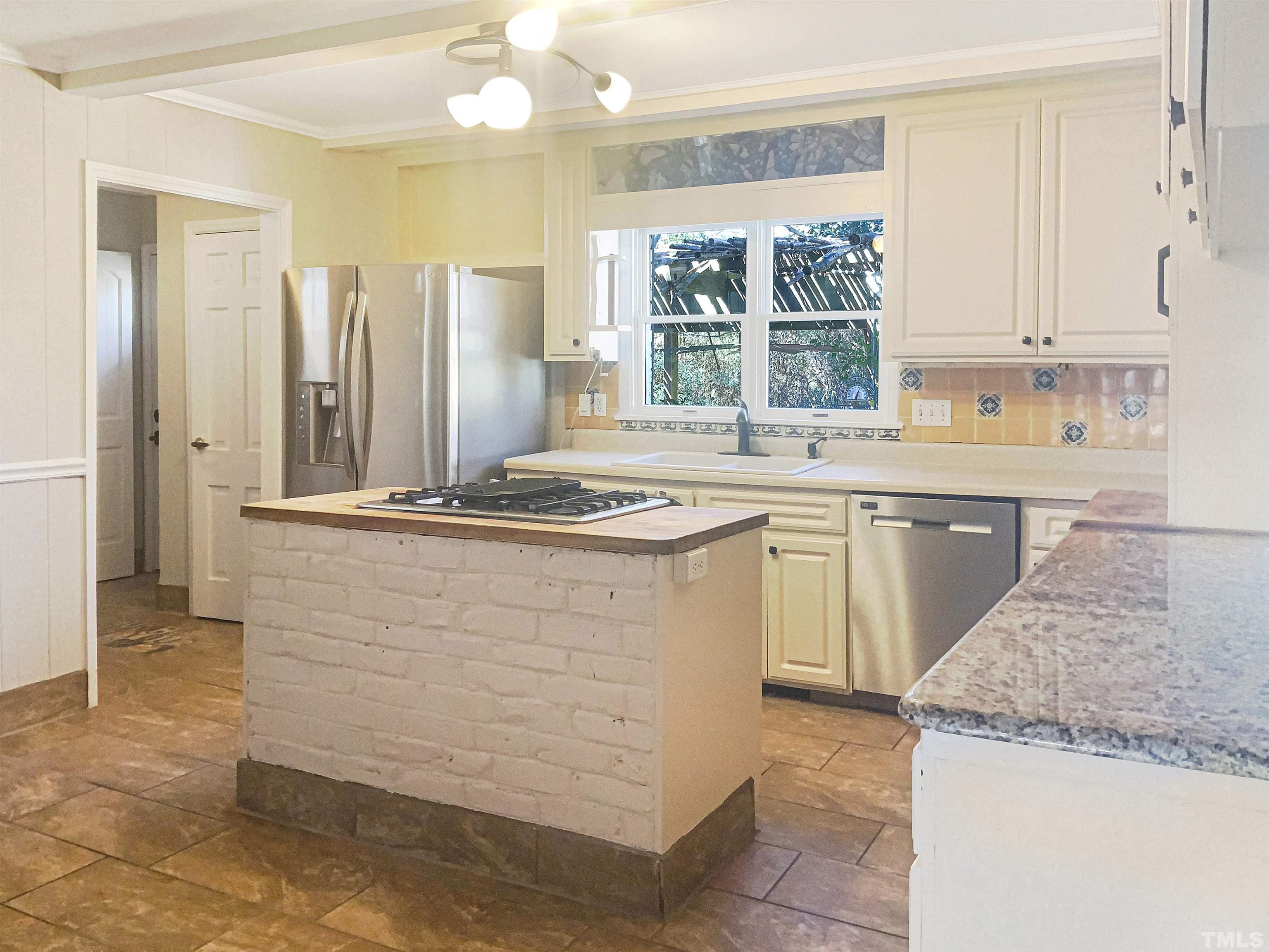 6717 Johnsdale Road Raleigh, NC 27615 - Photo 4 of 20 a kitchen with stainless steel appliances granite countertop a sink stove and refrigerator