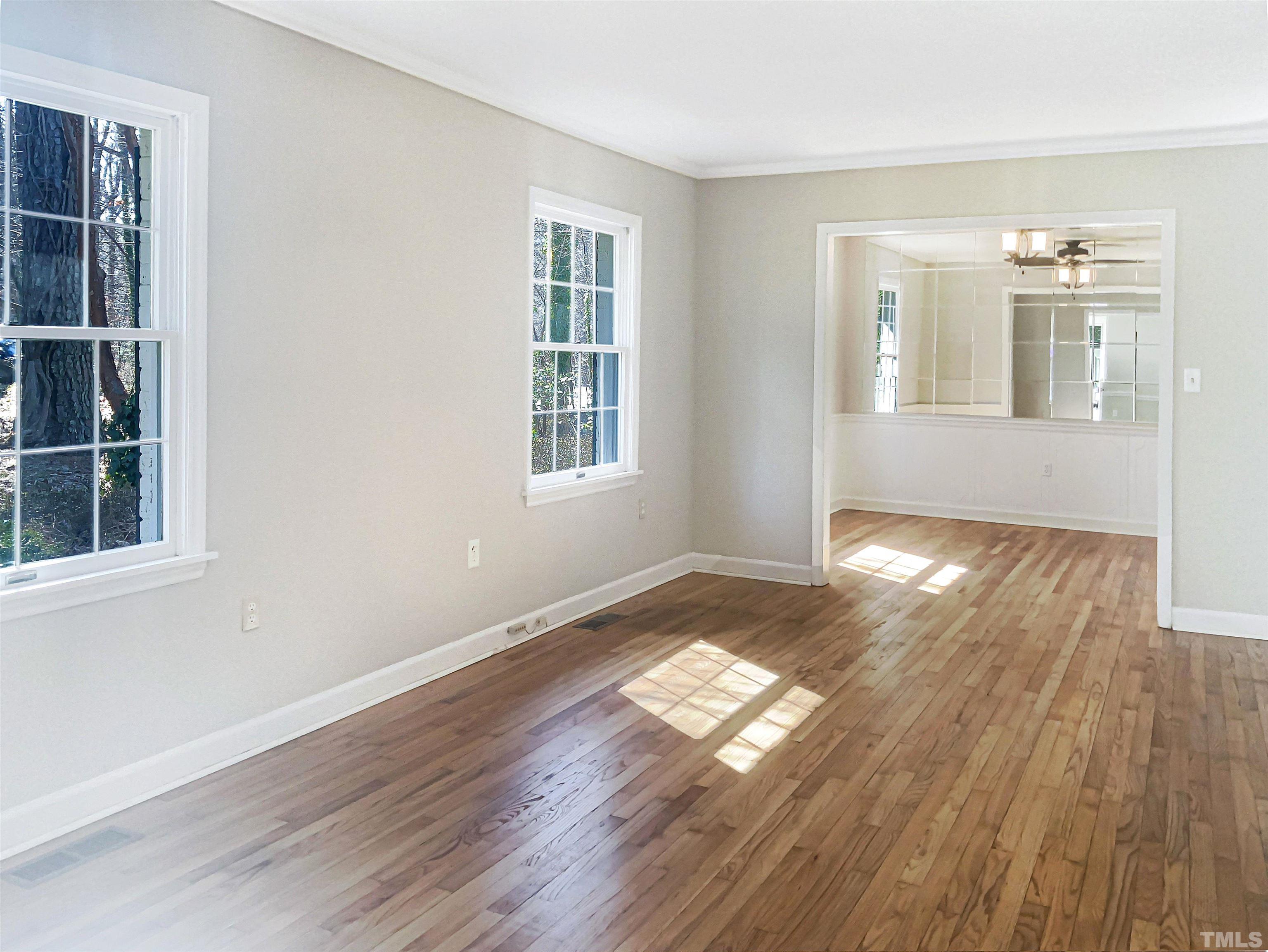 6717 Johnsdale Road Raleigh, NC 27615 - Photo 8 of 20 an empty room with wooden floor and windows