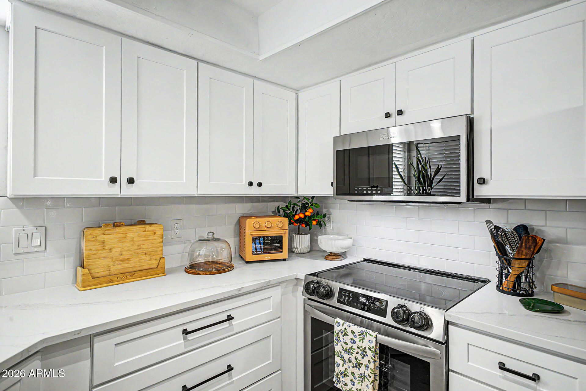 2455 East Broadway Road, Unit 65 Mesa, AZ 85204 - Photo 12 of 36 a kitchen with stainless steel appliances white cabinets and a stove top oven