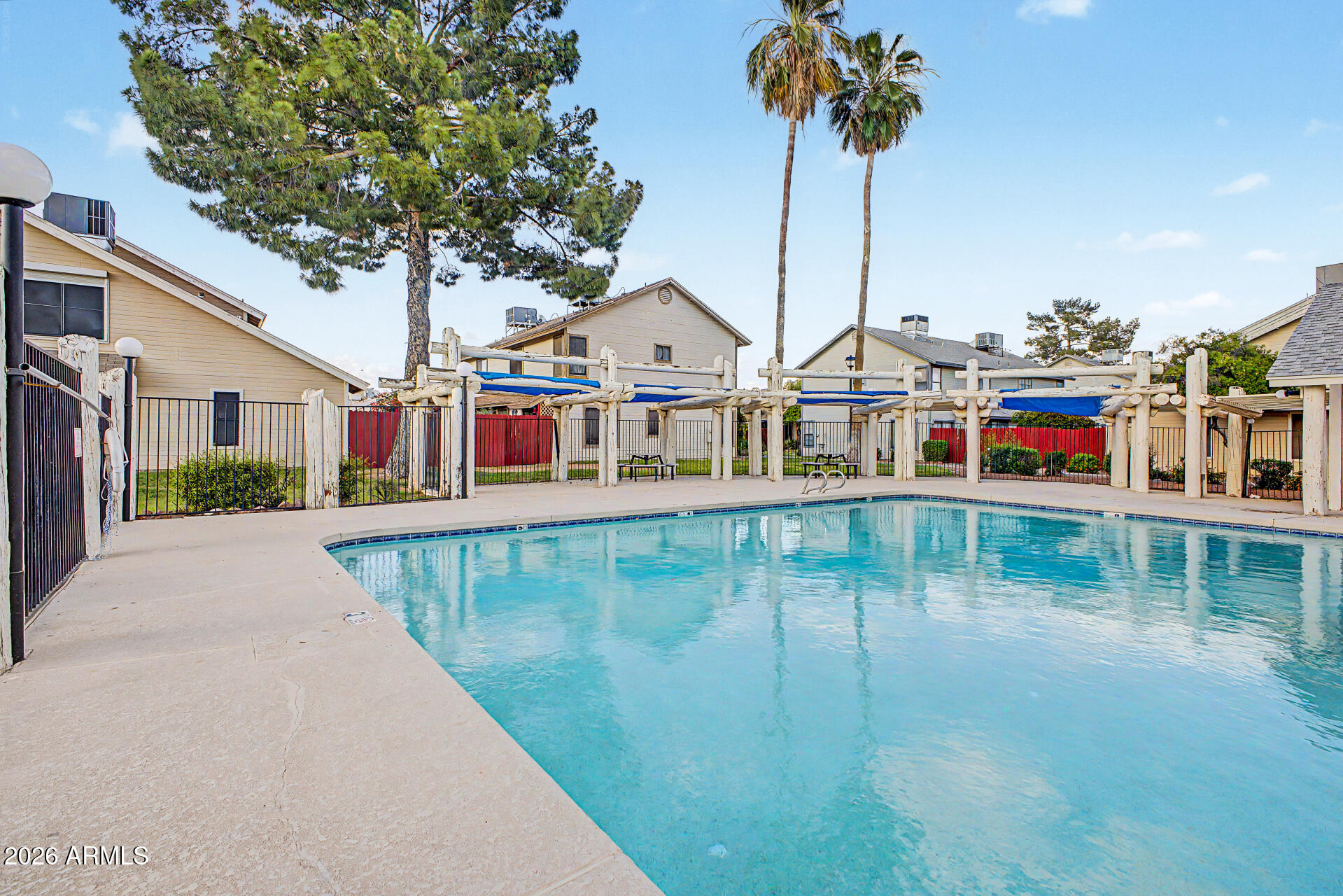 2455 East Broadway Road, Unit 65 Mesa, AZ 85204 - Photo 29 of 36 a view of a swimming pool with a yard and palm trees