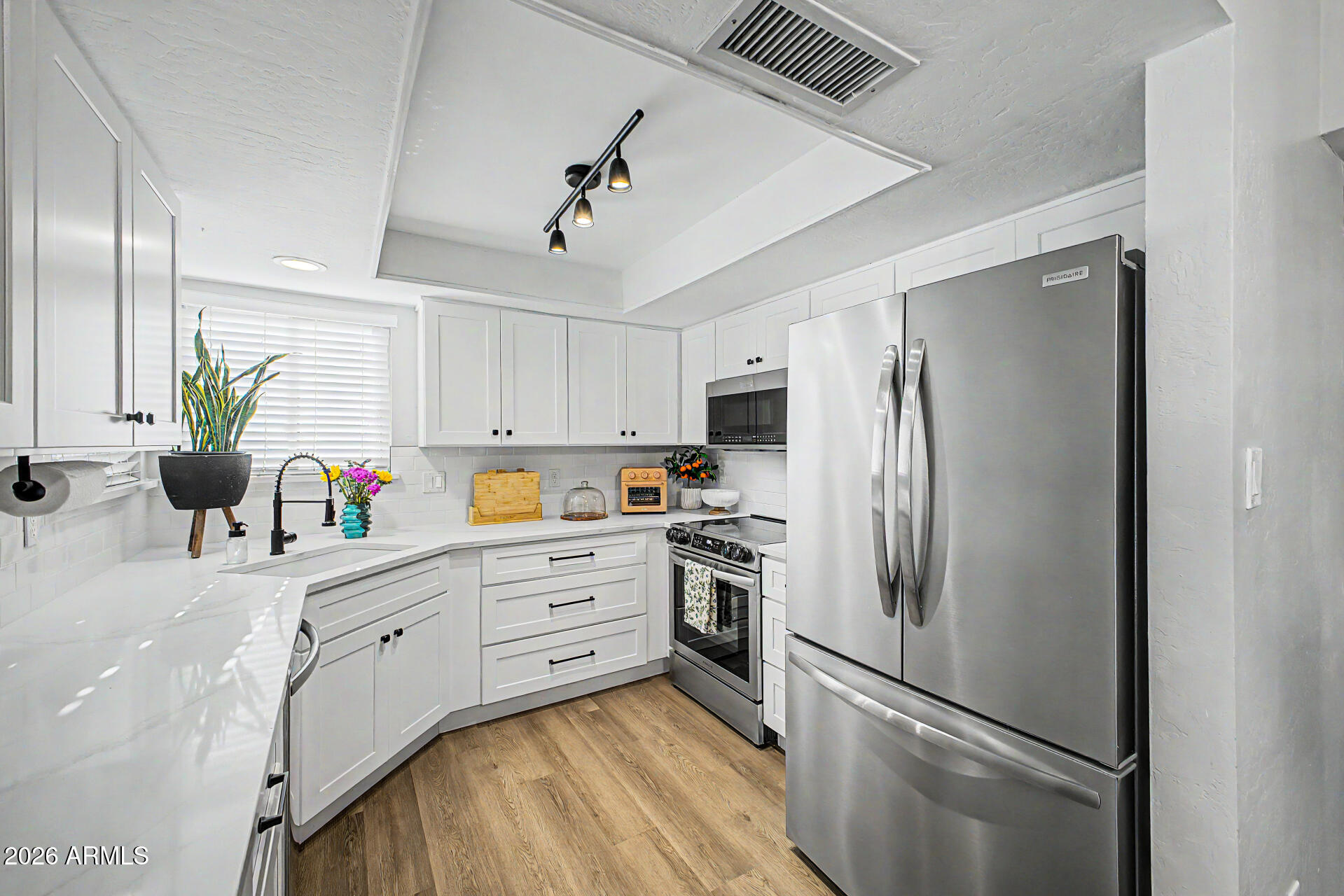 2455 East Broadway Road, Unit 65 Mesa, AZ 85204 - Photo 10 of 36 a kitchen with stainless steel appliances a refrigerator sink and cabinets