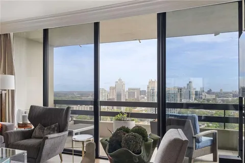 a balcony with furniture and a floor to ceiling window