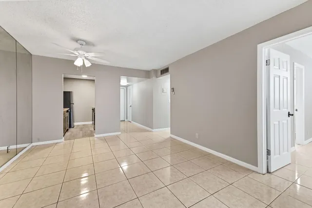 a view of a livingroom with a chandelier fan and windows