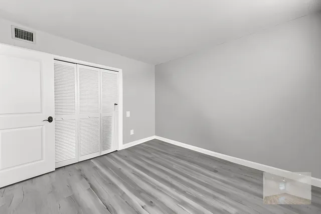 a view of an empty room with wooden floor