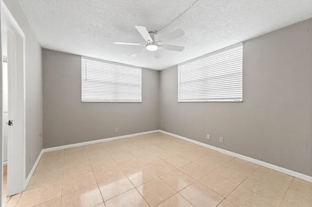 an empty room with closet and a ceiling fan