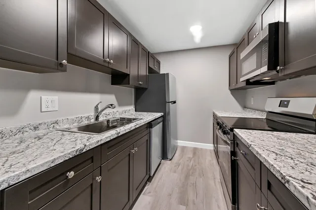 a kitchen with granite countertop stainless steel appliances and wooden cabinets