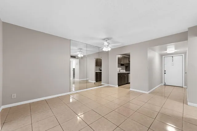 a view of an empty room with window and chandelier