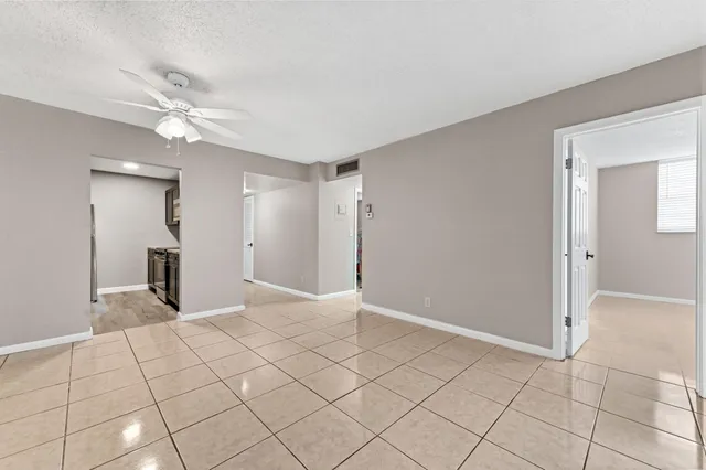 a view of an empty room and window chandelier fan