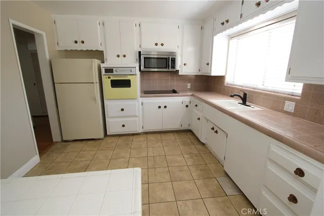 a kitchen with stainless steel appliances a refrigerator sink and microwave