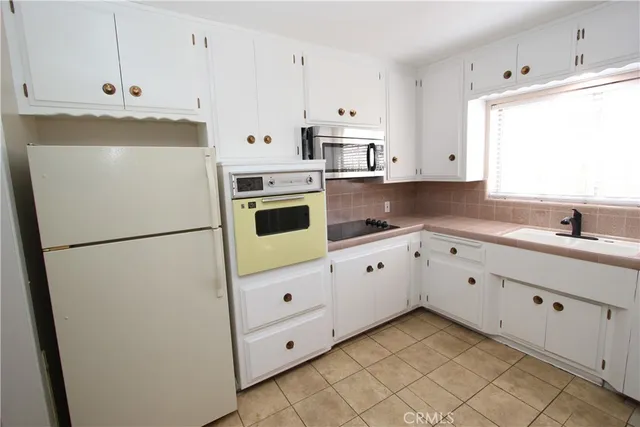 a white refrigerator freezer sitting inside of a kitchen