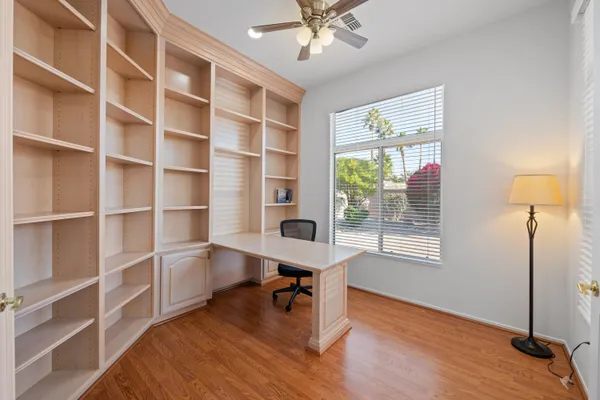 a view of a workspace with furniture and a window