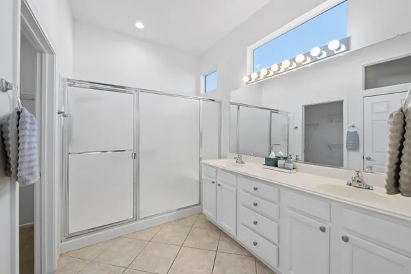 a bathroom with a double vanity sink mirror and shower