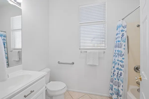 a bathroom with a sink a toilet and shower curtain