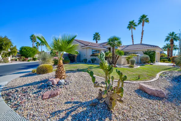 a view of a garden with a table and chairs under an umbrella