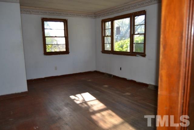 124 Harris Street Roxboro, NC 27573 - Photo 4 of 8 a view of empty room with wooden floor and fan