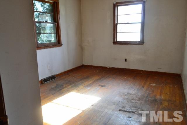 124 Harris Street Roxboro, NC 27573 - Photo 5 of 8 an empty room with wooden floor and windows