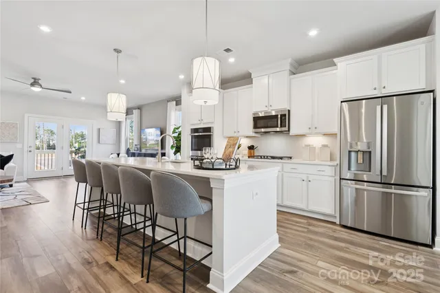 a kitchen with kitchen island granite countertop a sink cabinets and stainless steel appliances