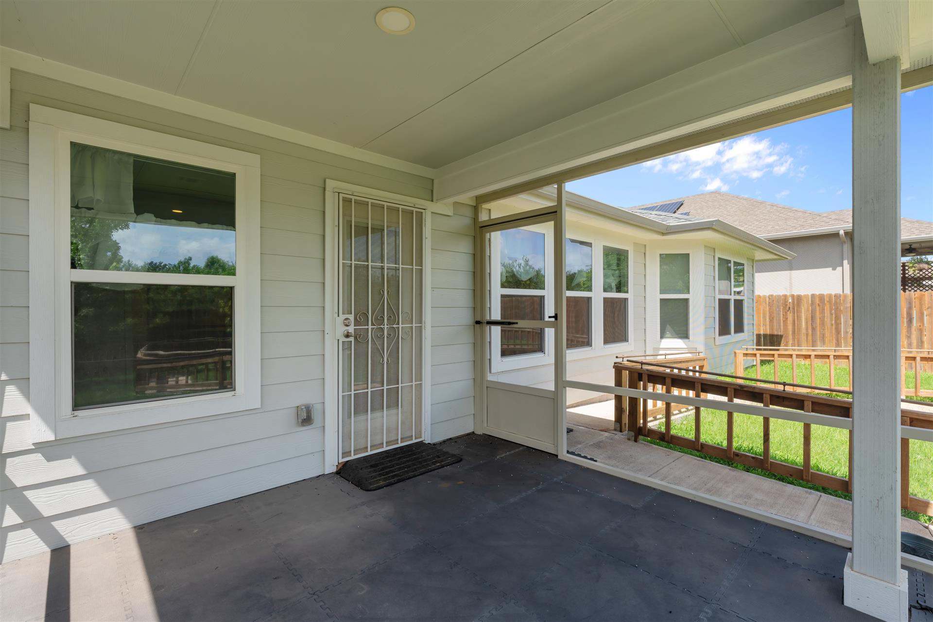 16512 Enamorado Road Manor, TX 78653 - Photo 29 of 31 An inviting covered patio features a screened enclosure leading to a lush, private yard.