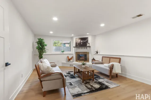 a living room with furniture fireplace and a rug