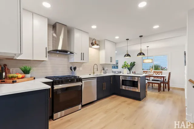 a kitchen with stainless steel appliances kitchen island granite countertop a stove a sink and a refrigerator