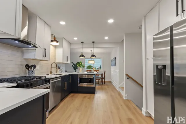 a kitchen with stainless steel appliances a stove a sink a refrigerator and cabinets