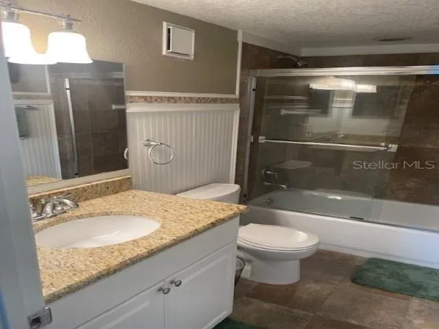 a bathroom with a granite countertop sink toilet and shower