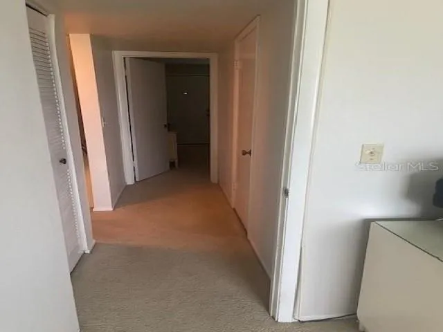 a view of a hallway with closet and wooden floor