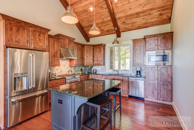 14 Goldenrod Road Boone, NC 28607 - Photo 10 of 16 a kitchen with stainless steel appliances granite countertop a refrigerator a sink dishwasher a stove and a dining table with wooden floor