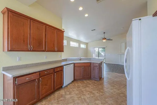 a open kitchen with stainless steel appliances granite countertop a refrigerator and a sink