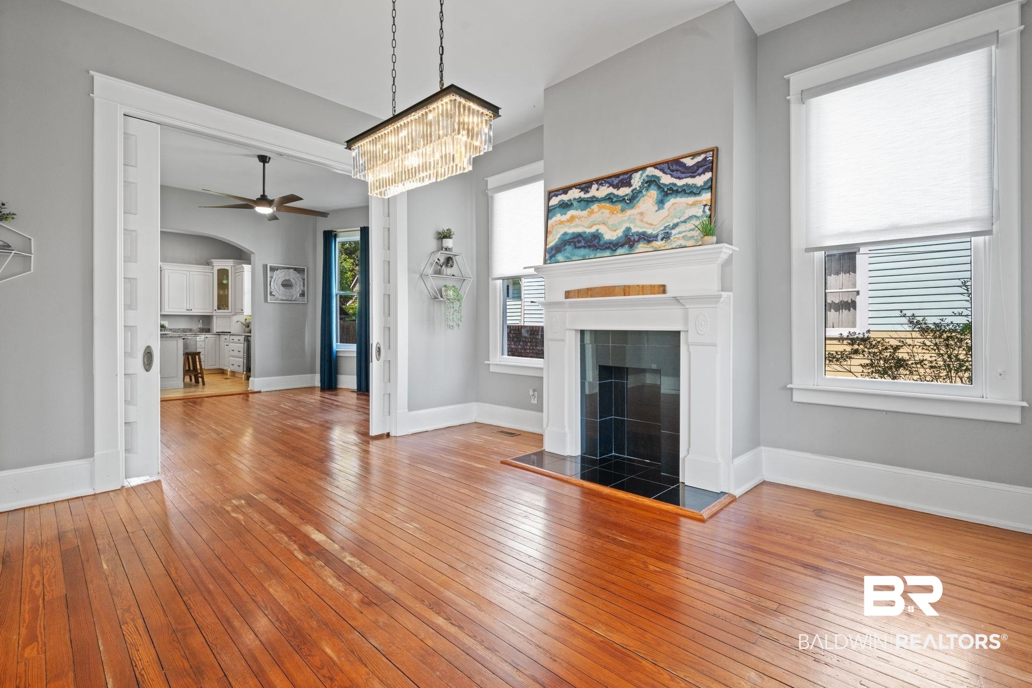 10 South Monterey Street Mobile, AL 36604 - Photo 8 of 45 Unfurnished living room with light wood-style flooring, arched walkways, a tile fireplace, ceiling fan, and a chandelier