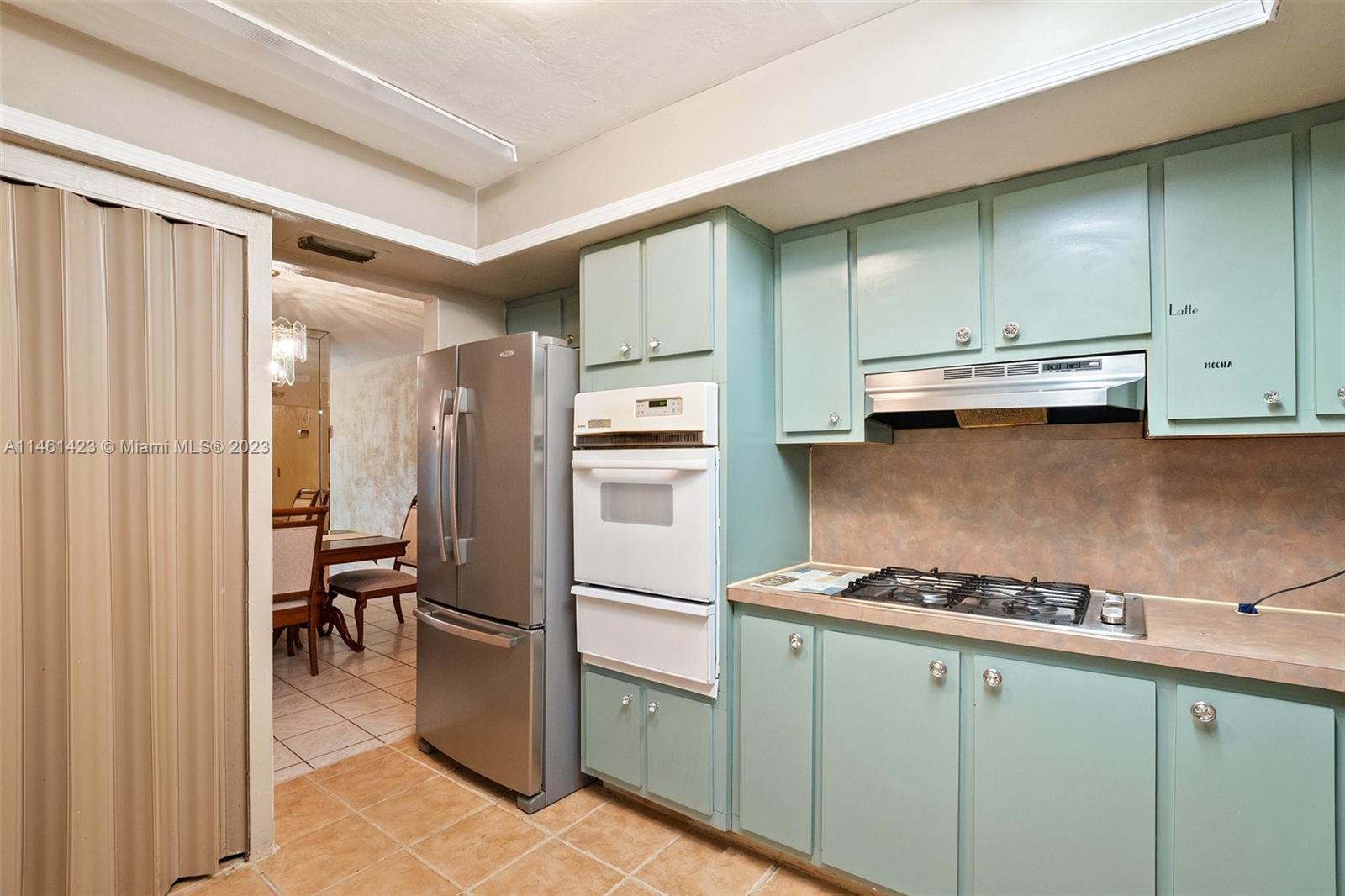 3405 East Shore Road Miramar, FL 33023 - Photo 12 of 25 a kitchen with a refrigerator and a stove top oven