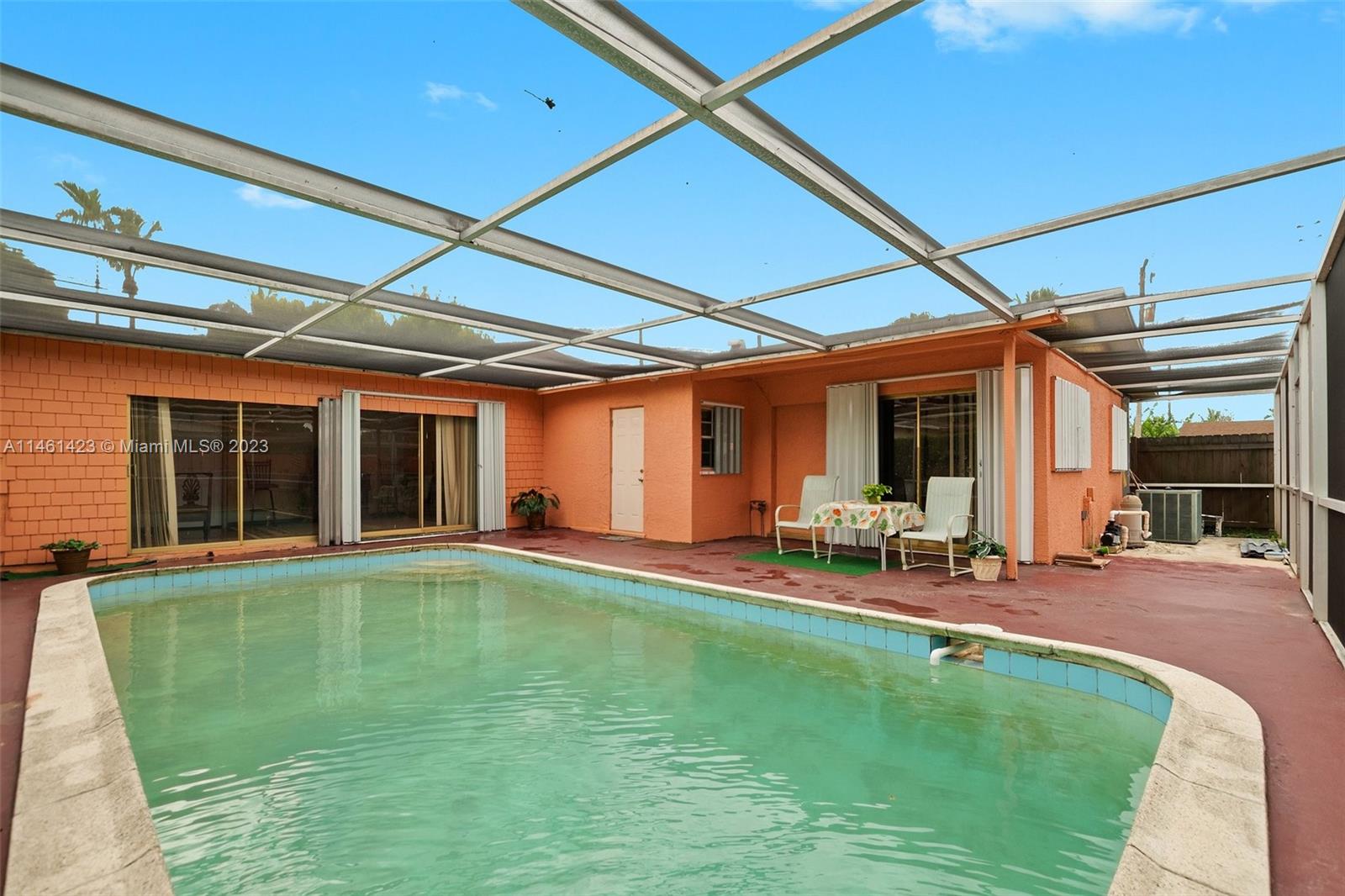 3405 East Shore Road Miramar, FL 33023 - Photo 23 of 25 a view of a backyard with table and chairs under an umbrella