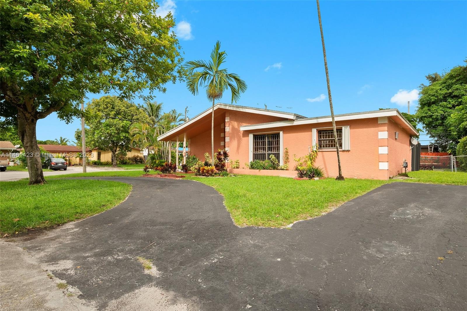 3405 East Shore Road Miramar, FL 33023 - Photo 3 of 25 a front view of a house with a yard and trees