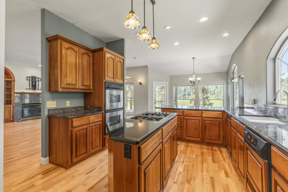 11756 Merganser Road Klamath Falls, OR 97601 - Photo 28 of 73 a kitchen with stainless steel appliances granite countertop a sink a stove and a wooden floors