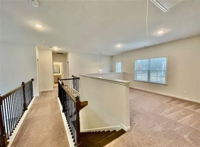 an empty room with windows and chandelier fan