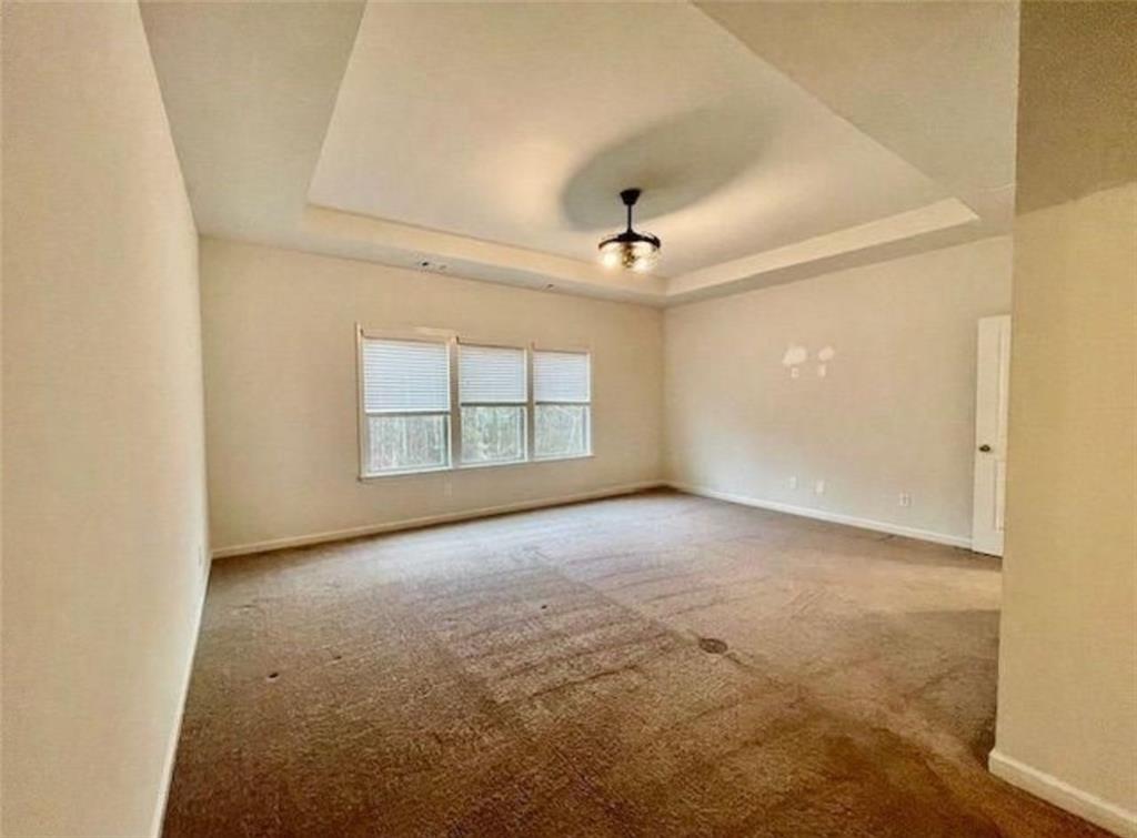 181 Charolais Drive McDonough, GA 30252 - Photo 18 of 25 an empty room with windows and chandelier fan