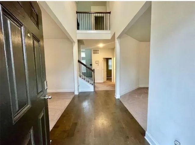 a view of a hallway with wooden floor and staircase