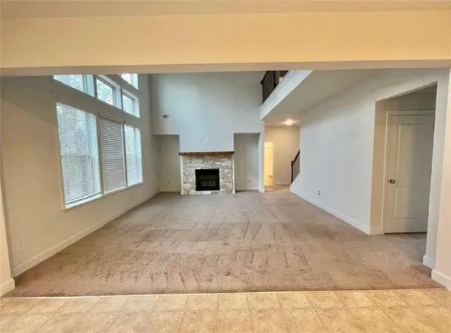 a view of an empty room with a fireplace and a window