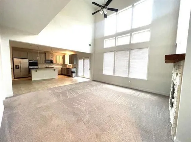 a view of a livingroom with a furniture a ceiling fan and window