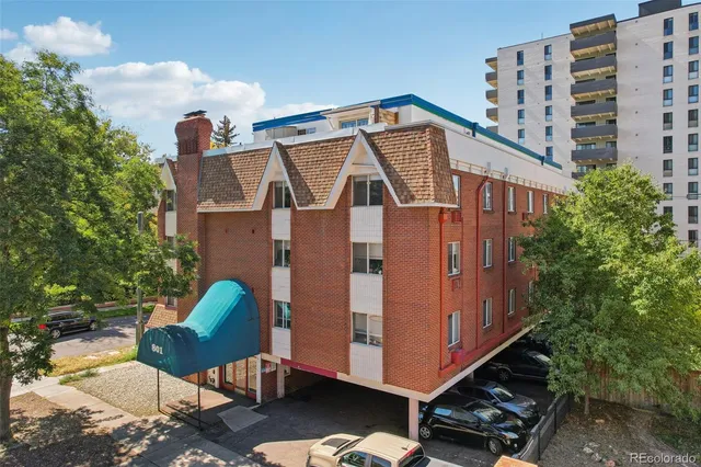 a view of a blue house with a yard and furniture